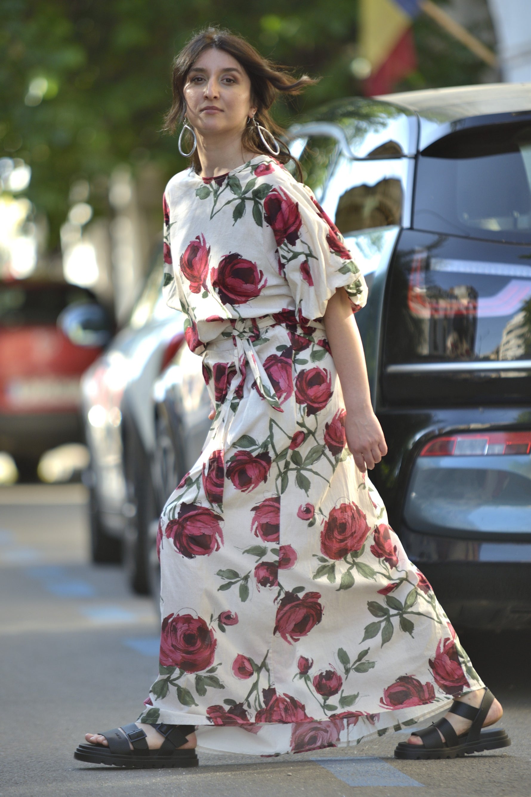  Fustă albă lungă cu imprimeu floral și talie marcată, purtată cu bluză asortată, fotografiată din lateral.