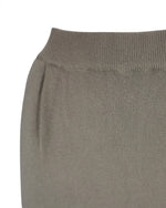 Detaliu lateral al unei fuste lungi din tricot moale, cu buzunare practice.