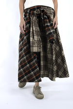 Detaliu de talie cu legare și suprapunere, evidențiind carourile contrastante ale fustei midi.