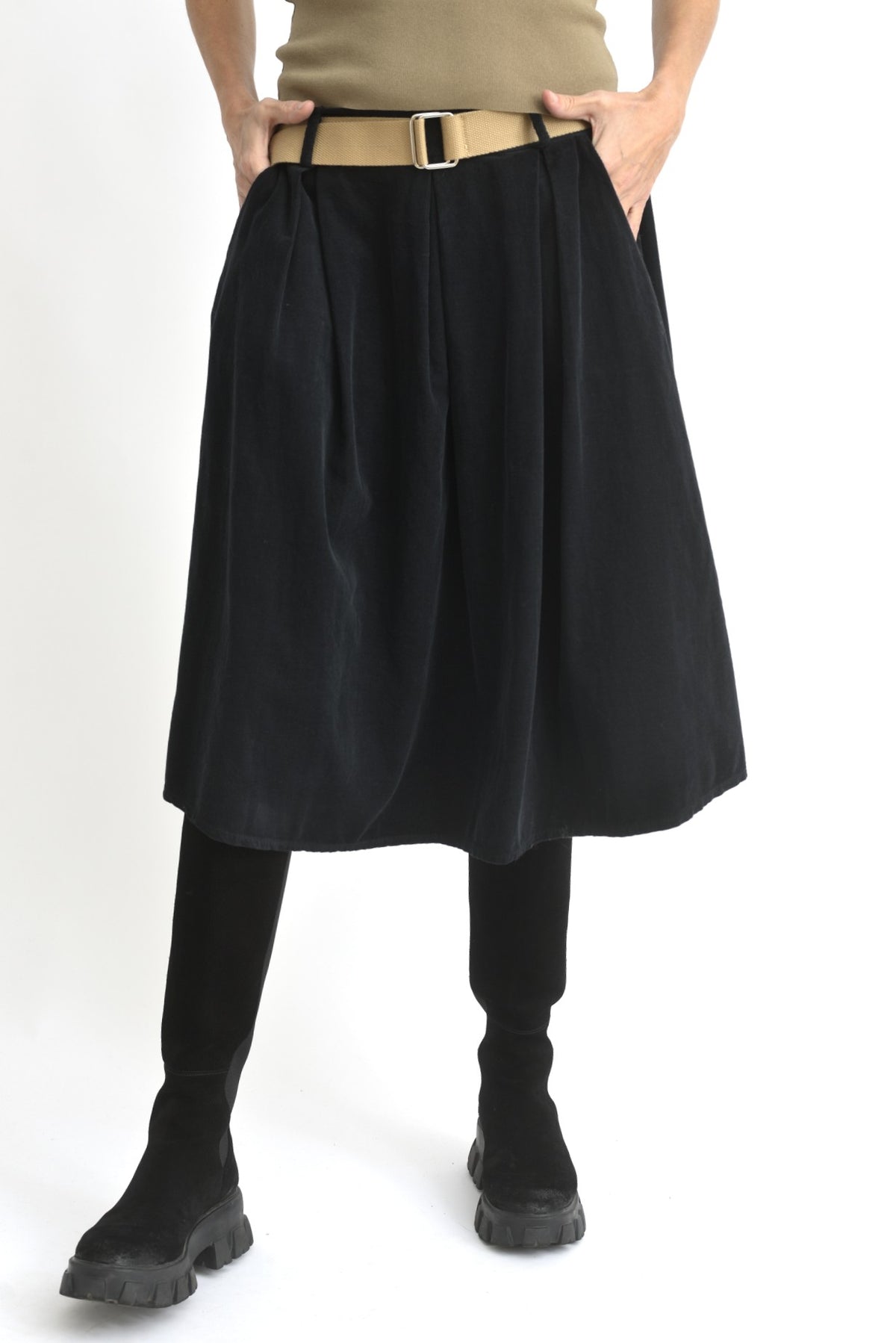 Imagine din spate cu fusta bleumarin 3/4 din catifea reiată, evidențiind căderea fluidă a materialului.