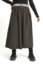 Fustă midi din catifea reiată neagră, afișată pe model, cu talie elastică și cădere amplă.