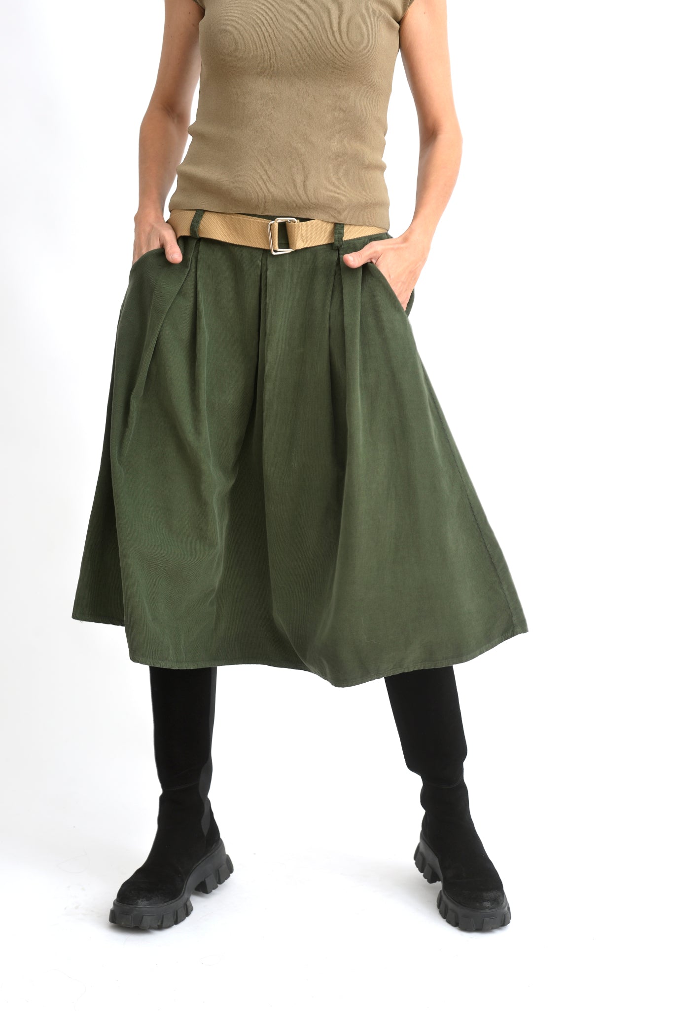 Detaliu lateral al fustei 3/4 din catifea reiată verde, material texturat și talie elastică.