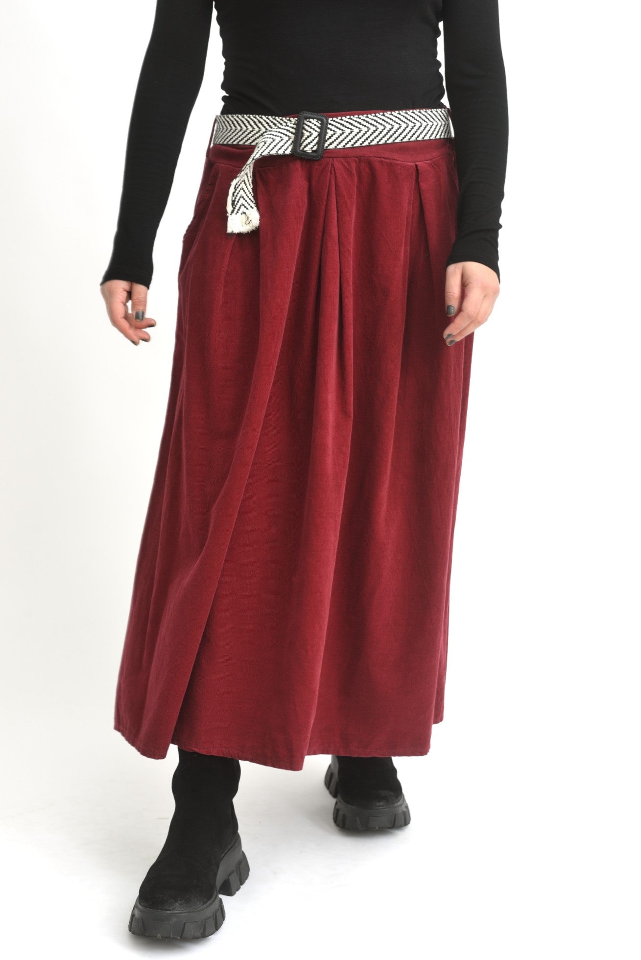 Fustă midi roșie din catifea reiată, cu talie elastică și design lejer, purtată de model.