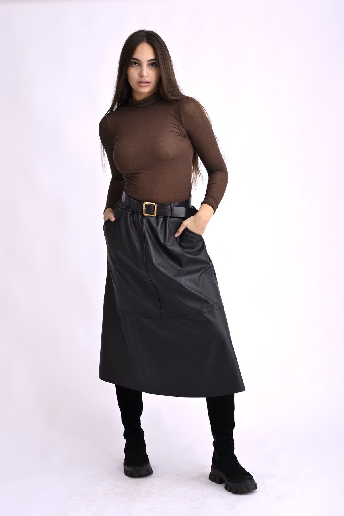 Model poartă o fustă midi cloș neagră, cu aspect de piele și talie înaltă, pe fundal alb.