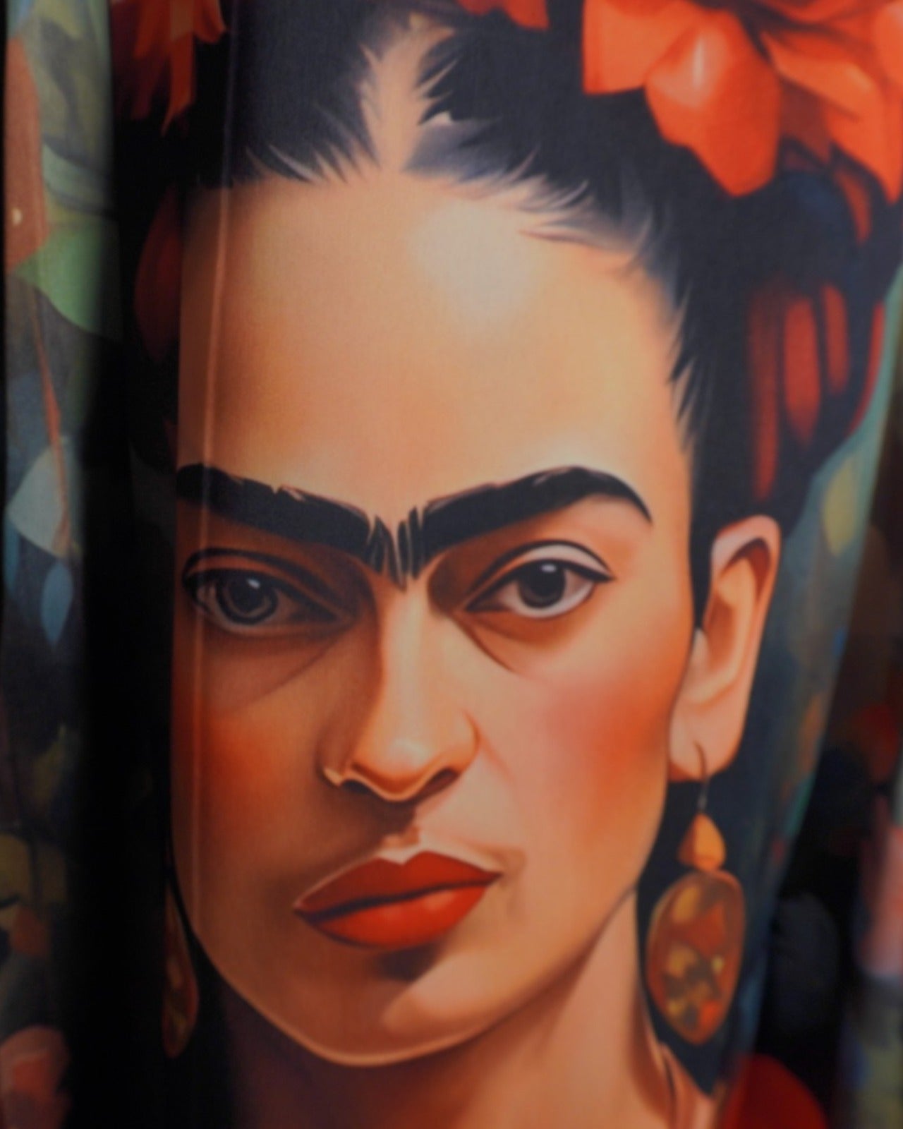 Prim-plan al imprimeului Frida Kahlo pe o fustă midi cu detalii fine și culori vii.