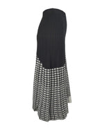 Vedere laterală a unei fuste midi evazate din tricot, cu design geometric alb-negru.