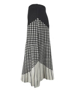 Vedere laterală a unei fuste midi evazate din tricot, cu design geometric alb-negru.
