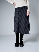 Detaliu buzunar aplicat cu clapă pe fustă midi gri în dungi, cu finisaj atent.