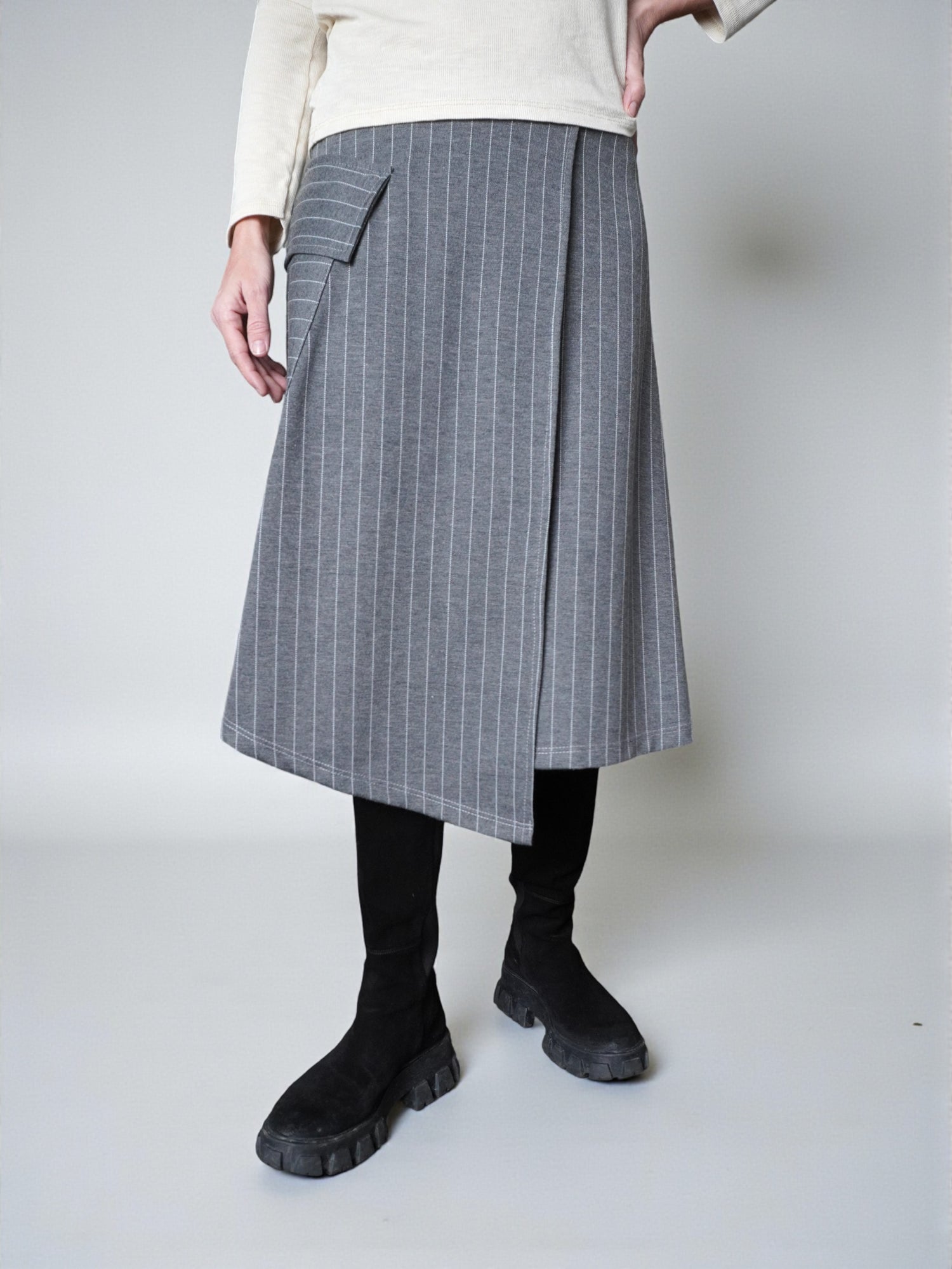 Fustă midi gri în dungi asortată cu pulover și bocanci, ținută de zi.