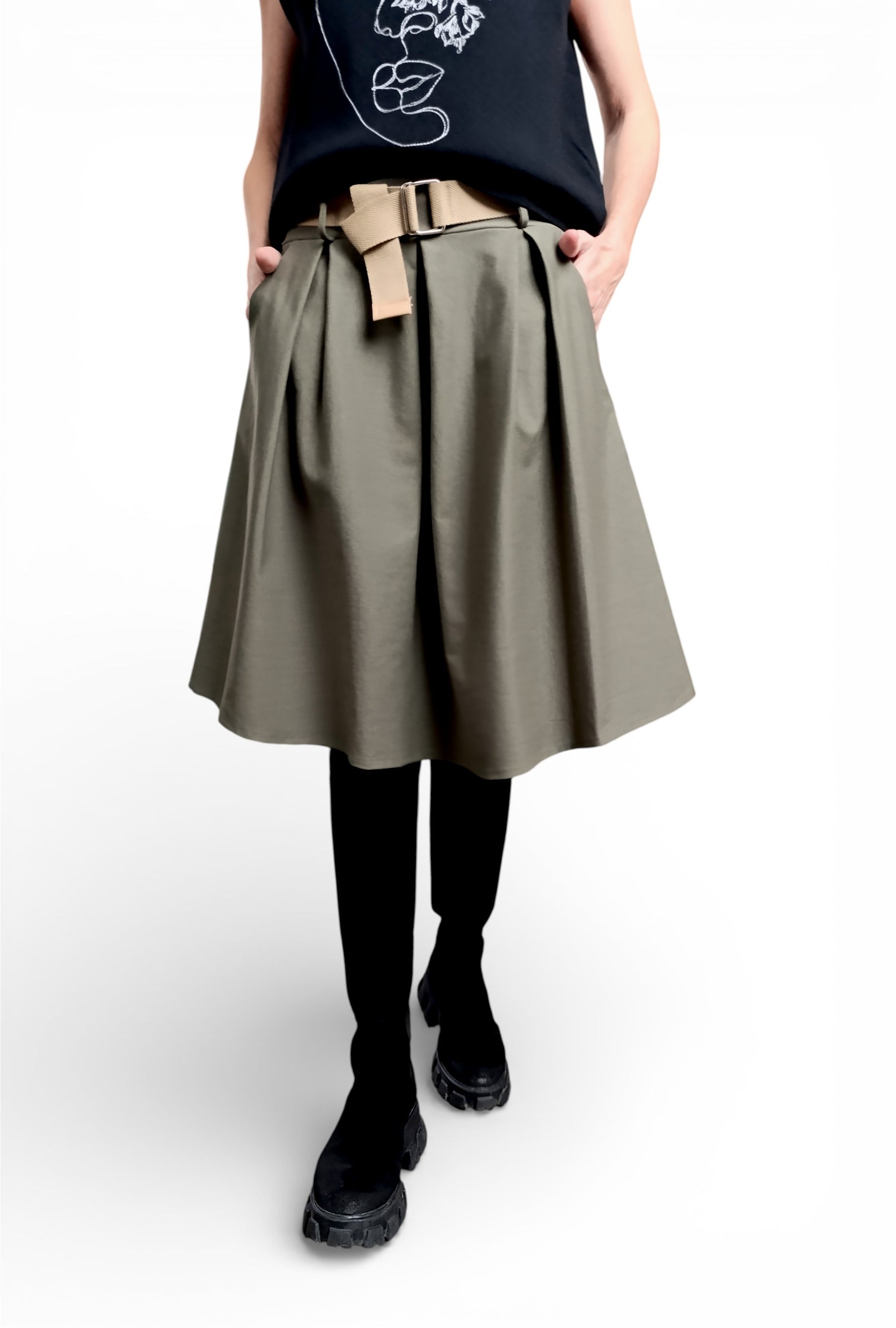 Fustă midi evazată neagră, purtată cu top imprimat și curea textilă, cu volum lejer și cădere fluidă.