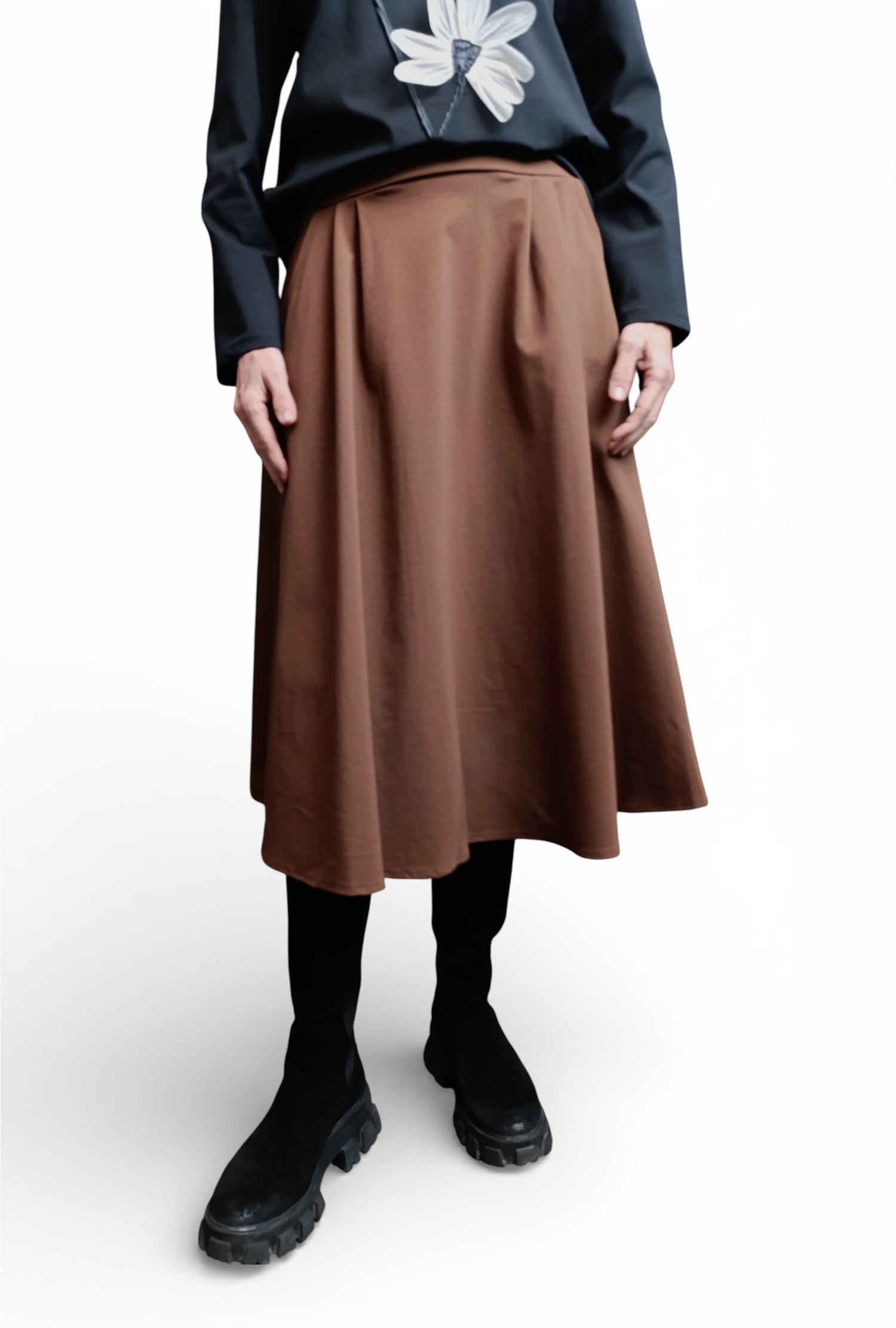 Fustă midi evazată maro, purtată cu bluză neagră, cu cădere amplă și finisaj curat, într-un look de zi.