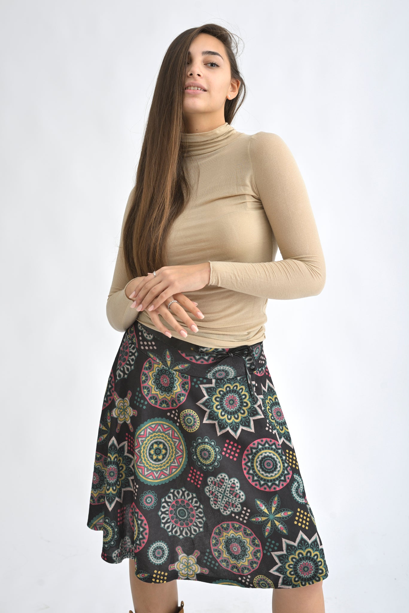 Fustă midi neagră cu imprimeu etnic multicolor, purtată de o femeie, vedere frontală.