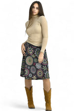 Fustă midi neagră cu imprimeu etnic, vedere laterală pe model, asortată cu bluză bej.
