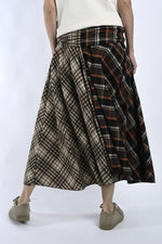 Vedere din spate a fustei midi petrecute, cu volum amplu și imprimeu în carouri în tonuri calde.