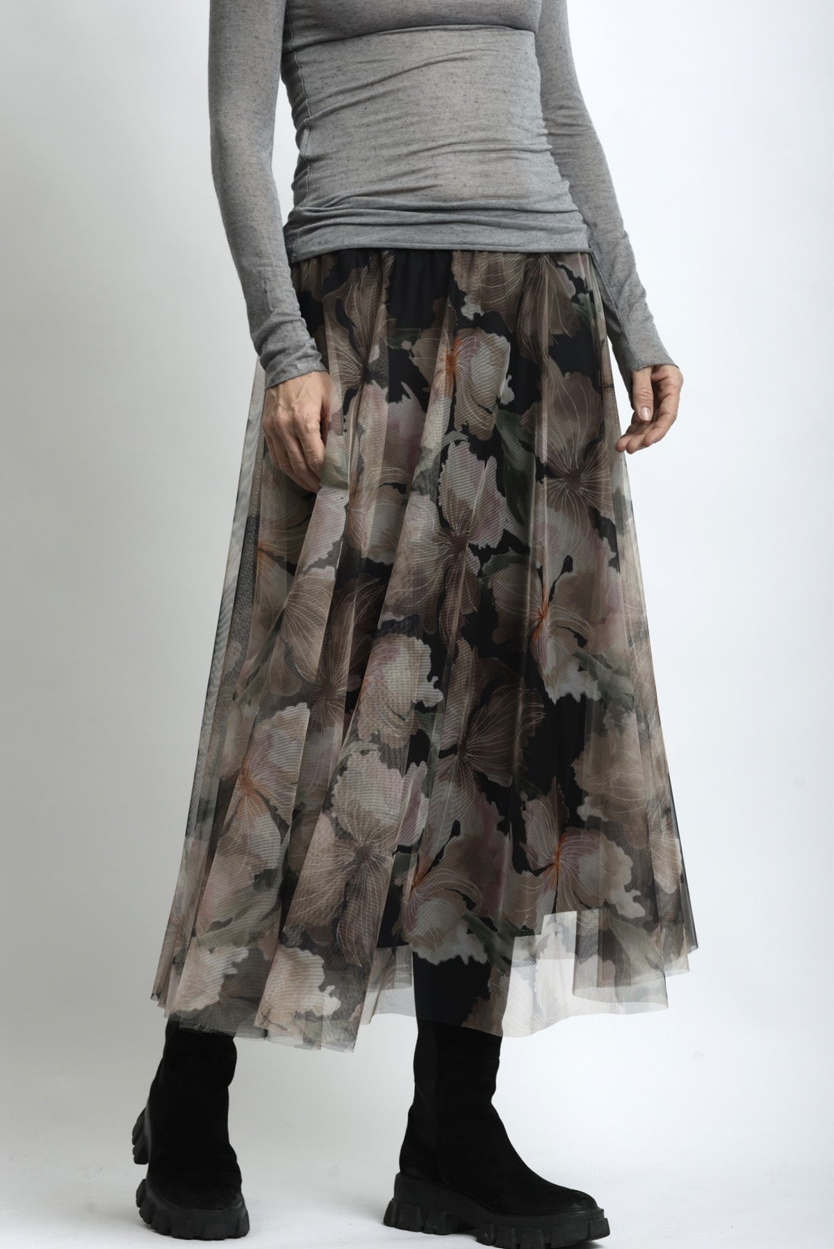 Detaliu material fustă din tulle cu imprimeu floral suprapus peste căptușeală opacă.