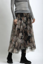 Detaliu material fustă din tulle cu imprimeu floral suprapus peste căptușeală opacă.