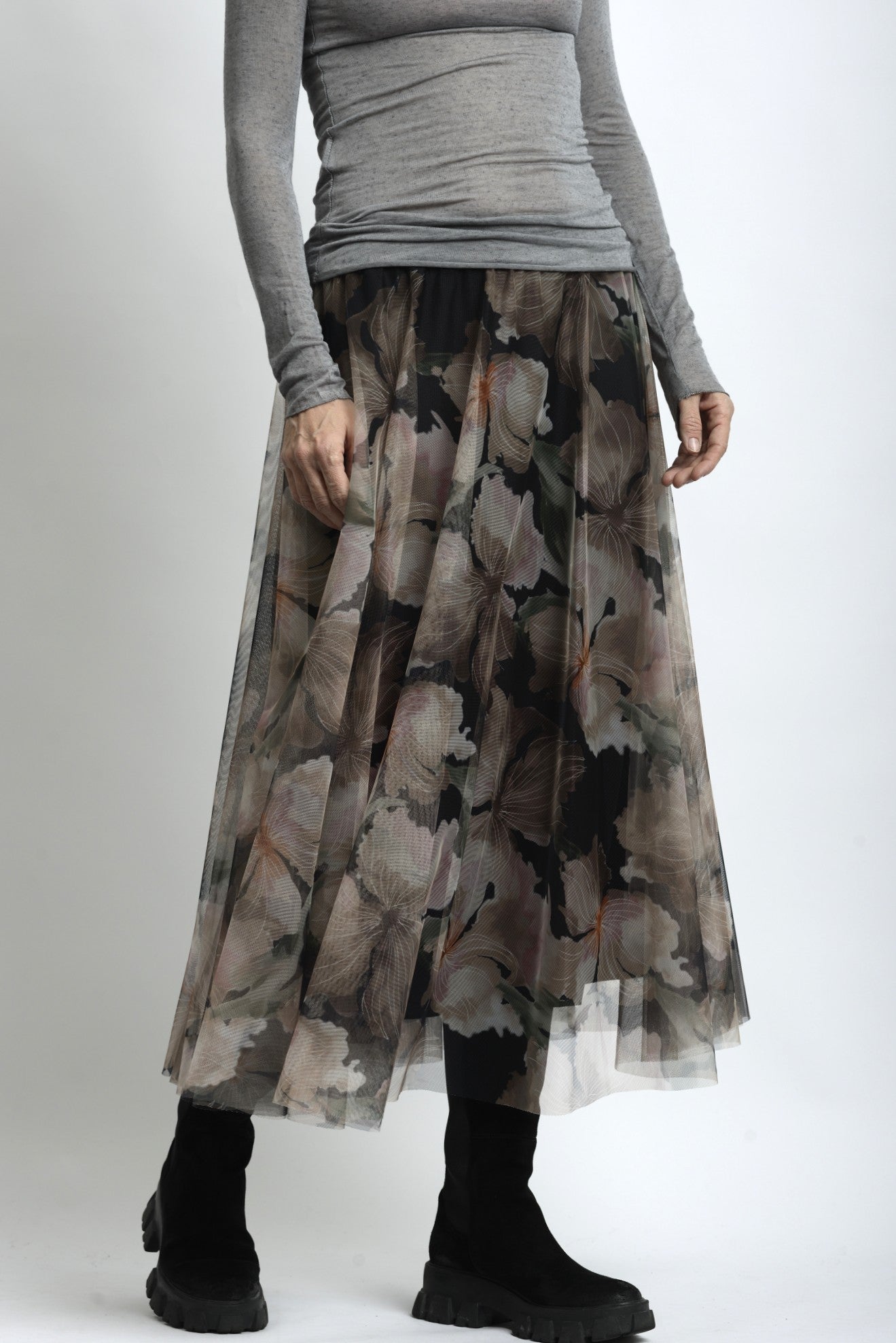 Detaliu material fustă din tulle cu imprimeu floral suprapus peste căptușeală opacă.