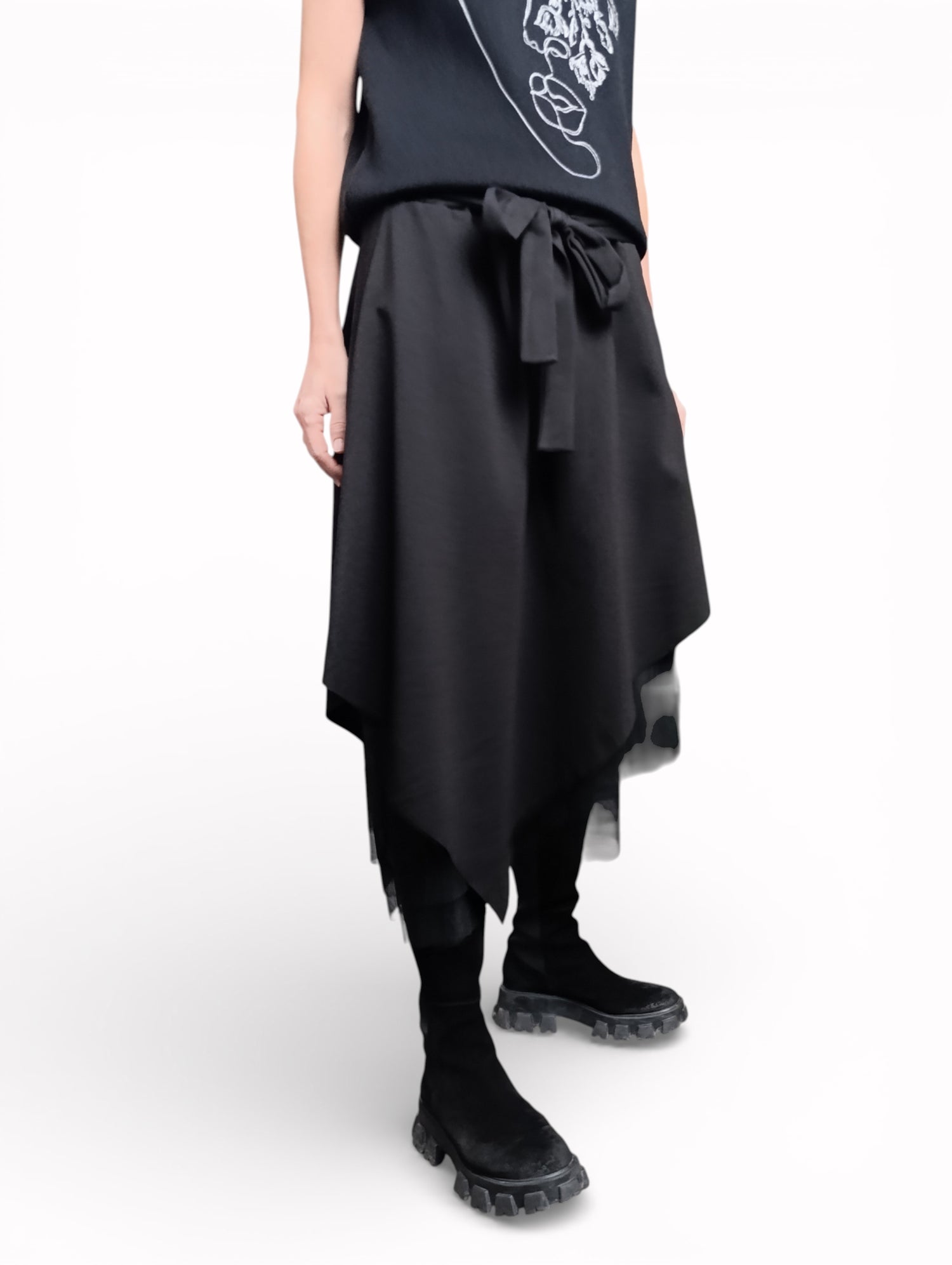 Vedere laterală a fustei negre cu tul, cu suprapuneri și tiv neregulat.