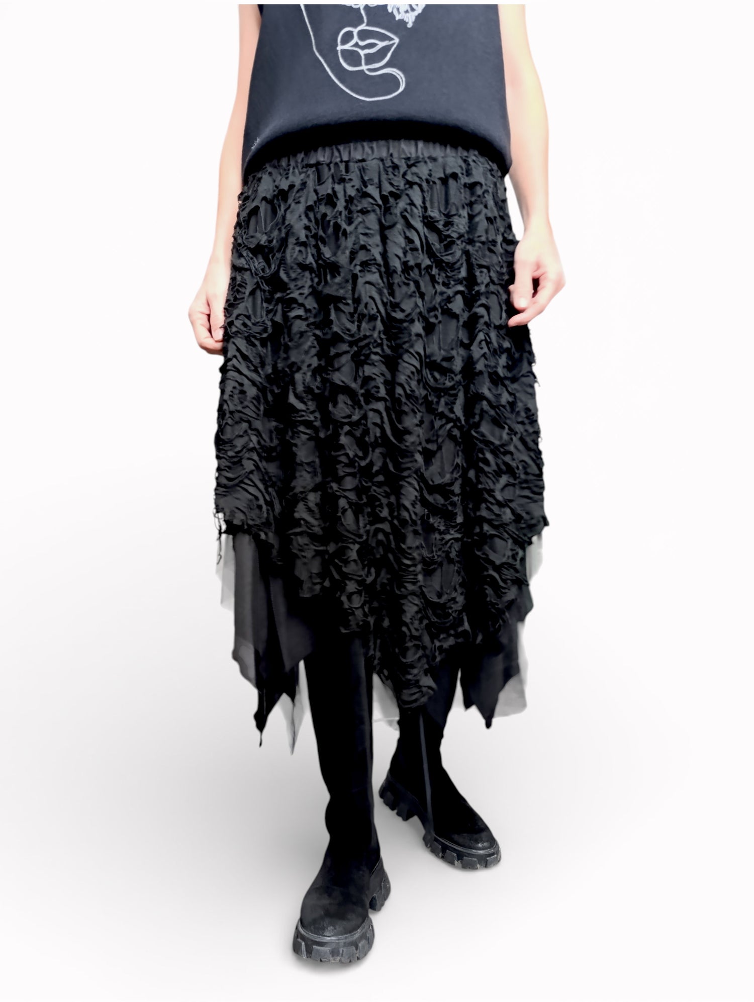 Fustă neagră fluidă cu strat dublu, surprinsă în mișcare, evidențiind transparențele.