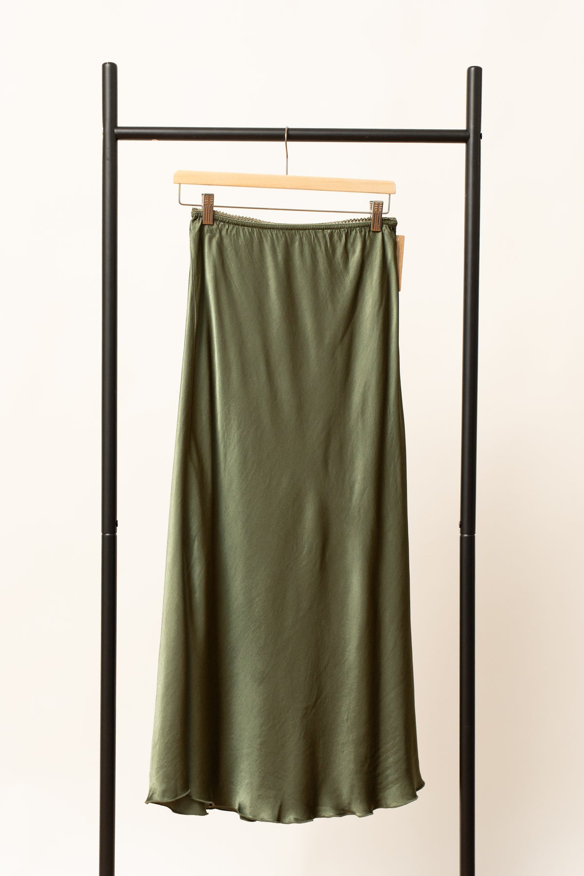 Fustă satinată verde, lungime midi, expusă pe umeraș negru, cu talie elastică.