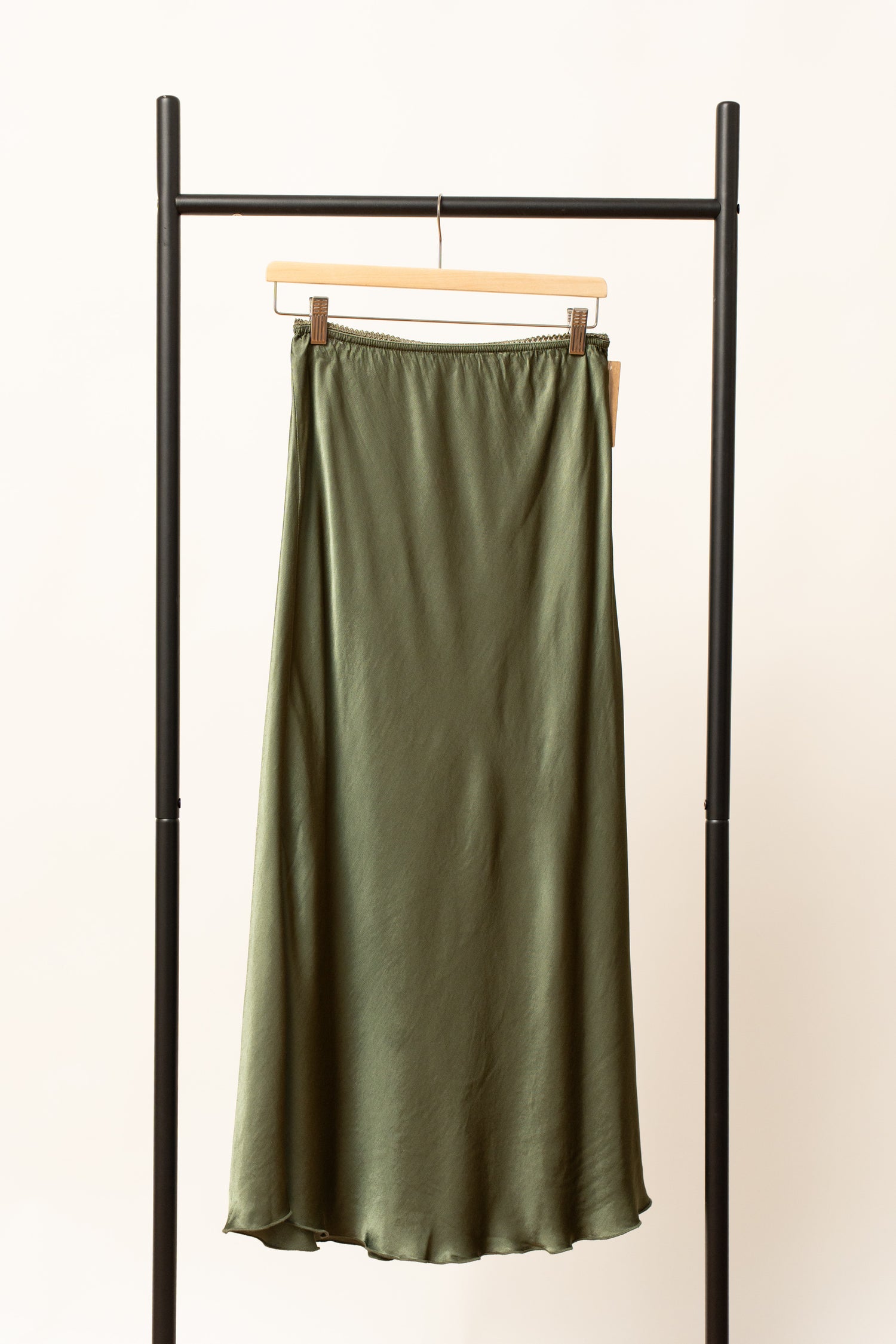 Fustă satinată verde, lungime midi, expusă pe umeraș negru, cu talie elastică.
