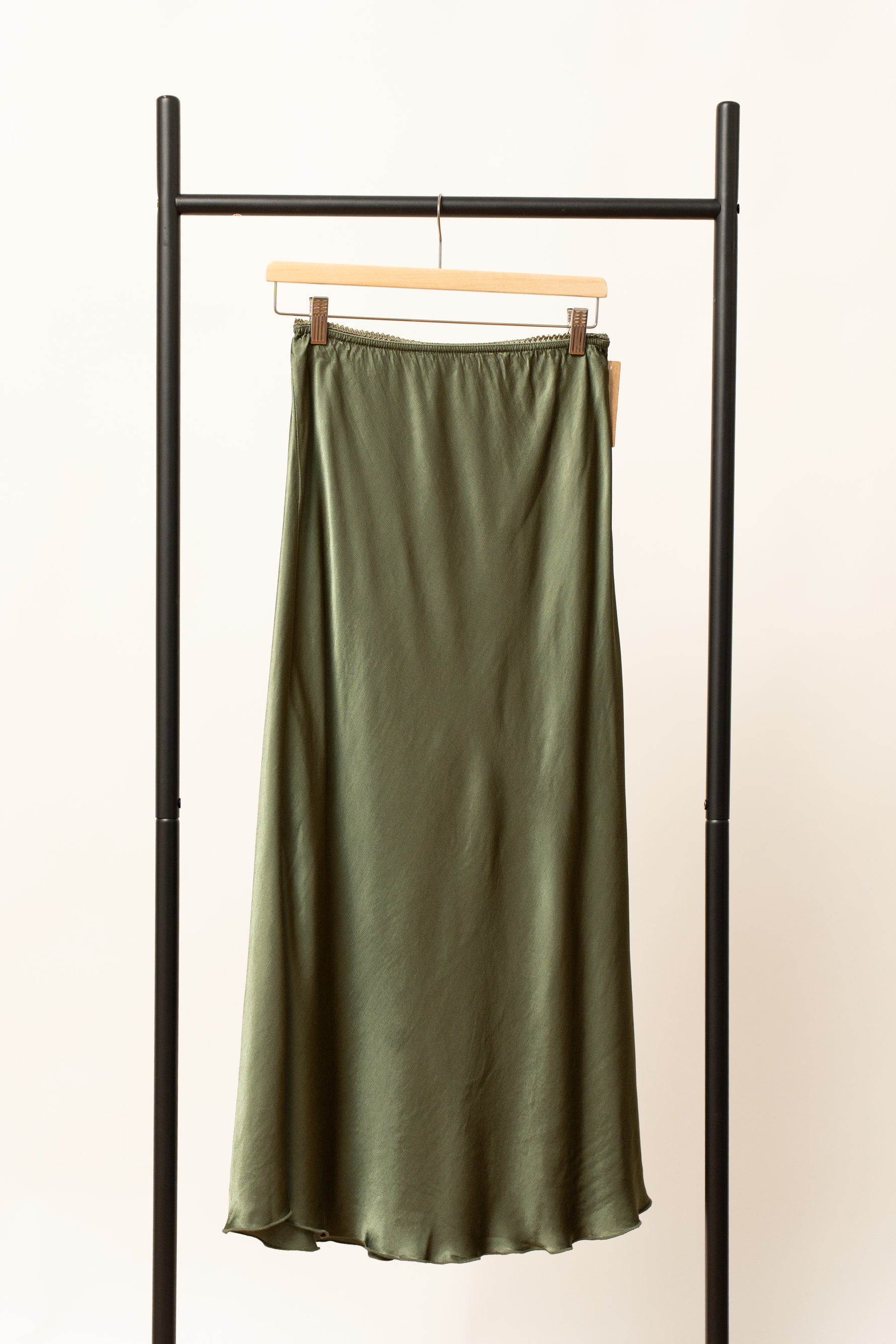Fustă satinată verde, lungime midi, expusă pe umeraș negru, cu talie elastică.