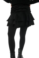 Vedere din spate a fustei scurte negre cu falduri și jupă pantalon, talie confortabilă și finisaj curat.