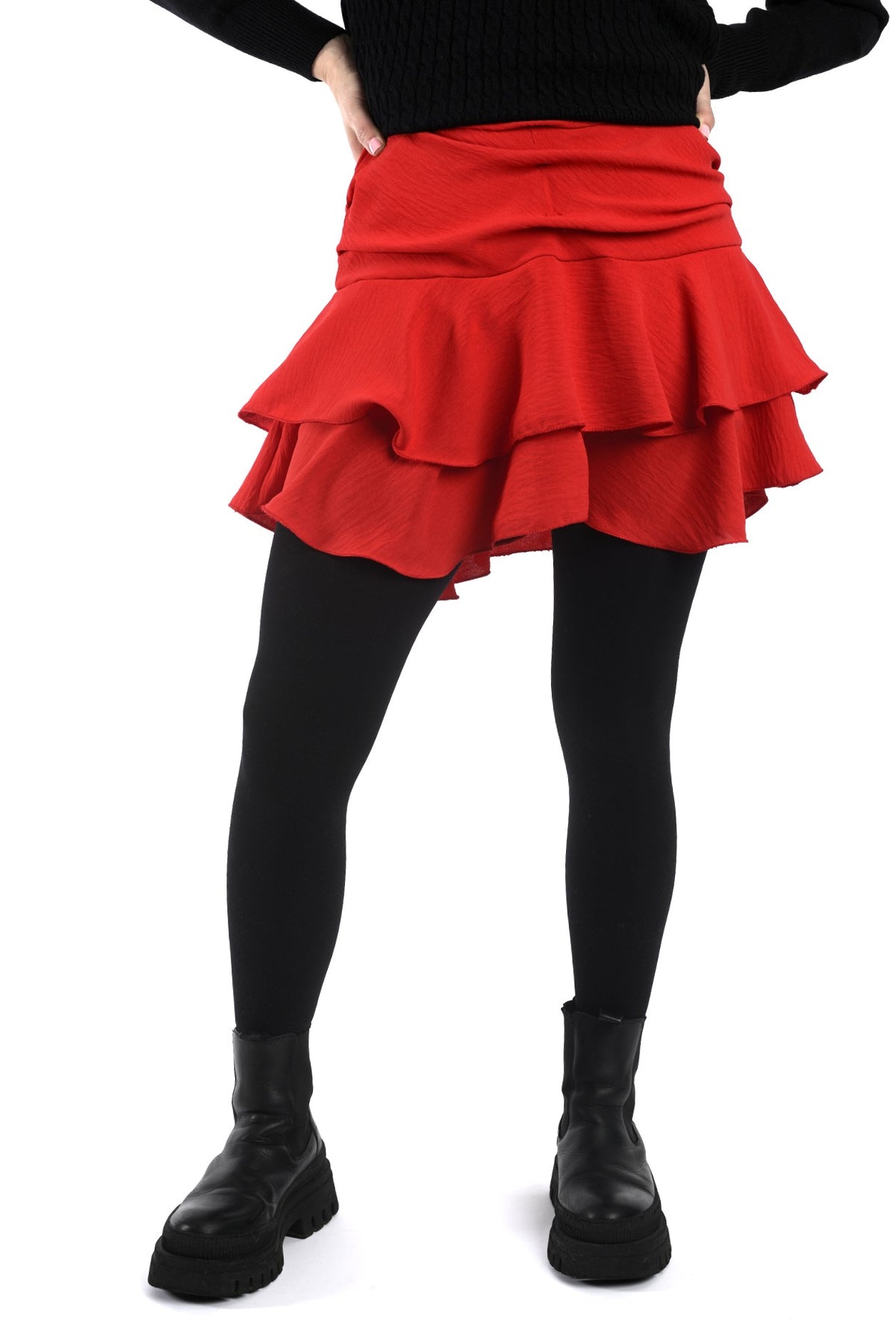 Detaliu lateral fustă scurtă neagră cu falduri, croială lejeră și volum natural în mișcare.