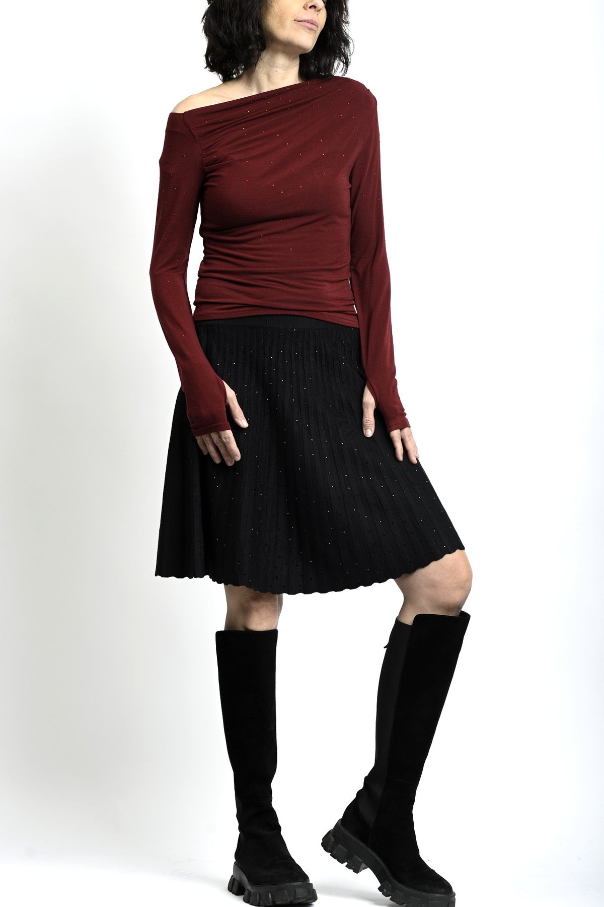 Ținută casual cu fustă scurtă din tricot cu straturi mici, purtată cu cizme înalte.