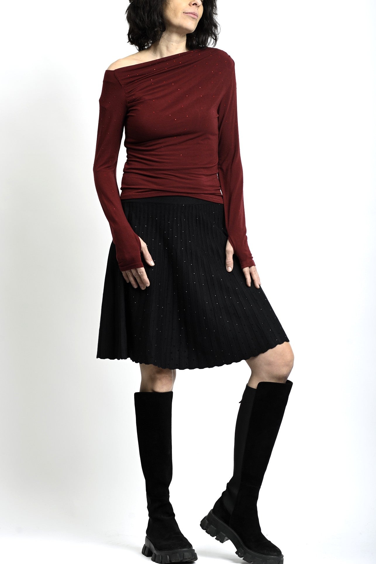 Ținută casual cu fustă scurtă din tricot cu straturi mici, purtată cu cizme înalte.