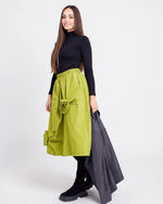 Fustă verde tip tafta, croială amplă, cu flori aplicate decorativ și talie elastică, purtată pe model.