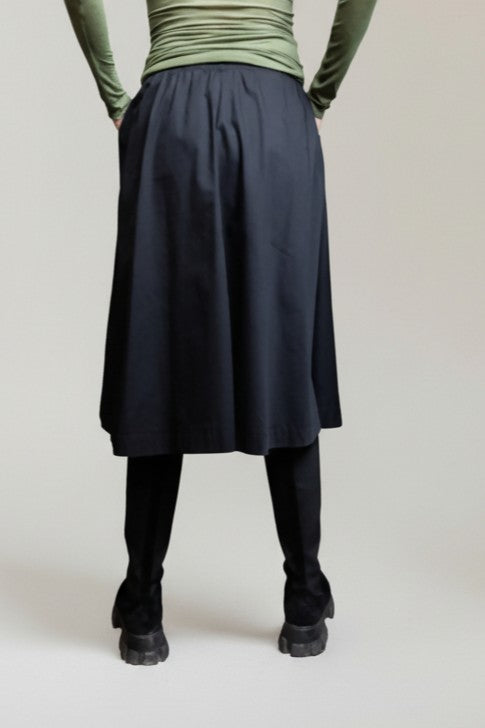 Vedere din spate a fustei tip A din bumbac, cu talie elastică și lungime midi.