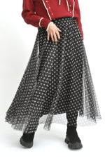 Fustă midi din tul cu buline mici albe pe fundal negru, vedere completă cu pliuri elegante.