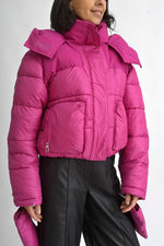 Detaliu al glugii geacă scurtă fucsia, cu guler înalt și sistem de prindere cu fermoar și capse.