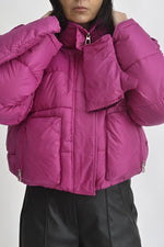 Detaliu al glugii geacă scurtă fucsia, cu guler înalt și sistem de prindere cu fermoar și capse.