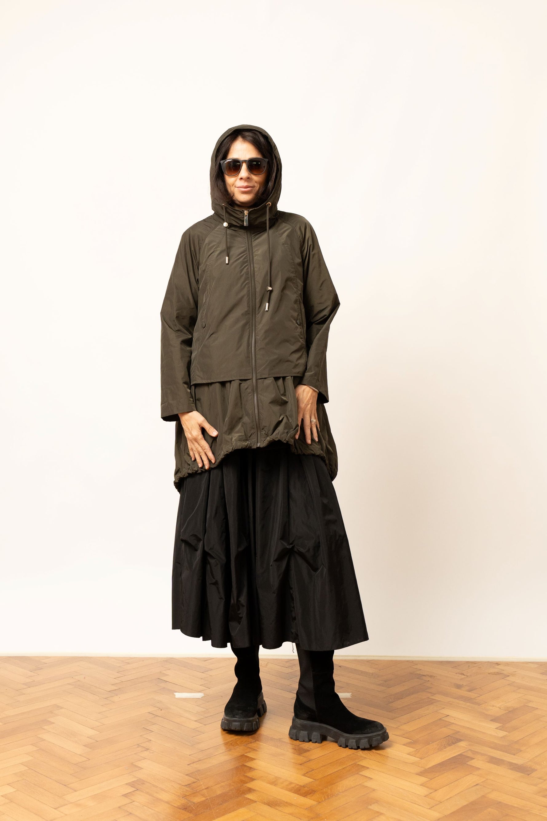 Geacă scurtă oversize khaki cu glugă ridicată și detaliu plisat la tiv, vedere frontală.