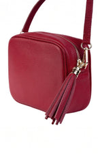 Geantă crossbody roșie din piele ecologică, cu detaliu de ciucure și curea reglabilă.