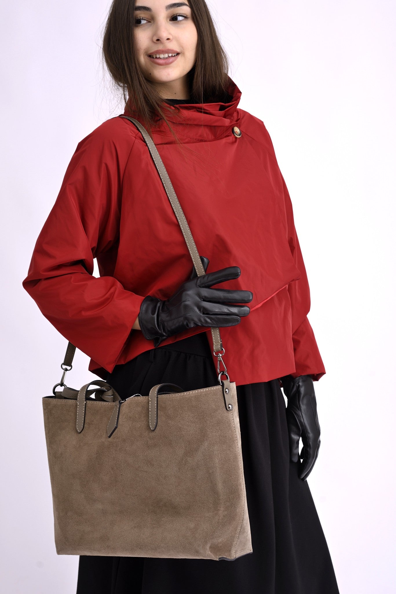 Detaliu al mânerelor și texturii catifelate ale genții din piele întoarsă, culoare bej natural.