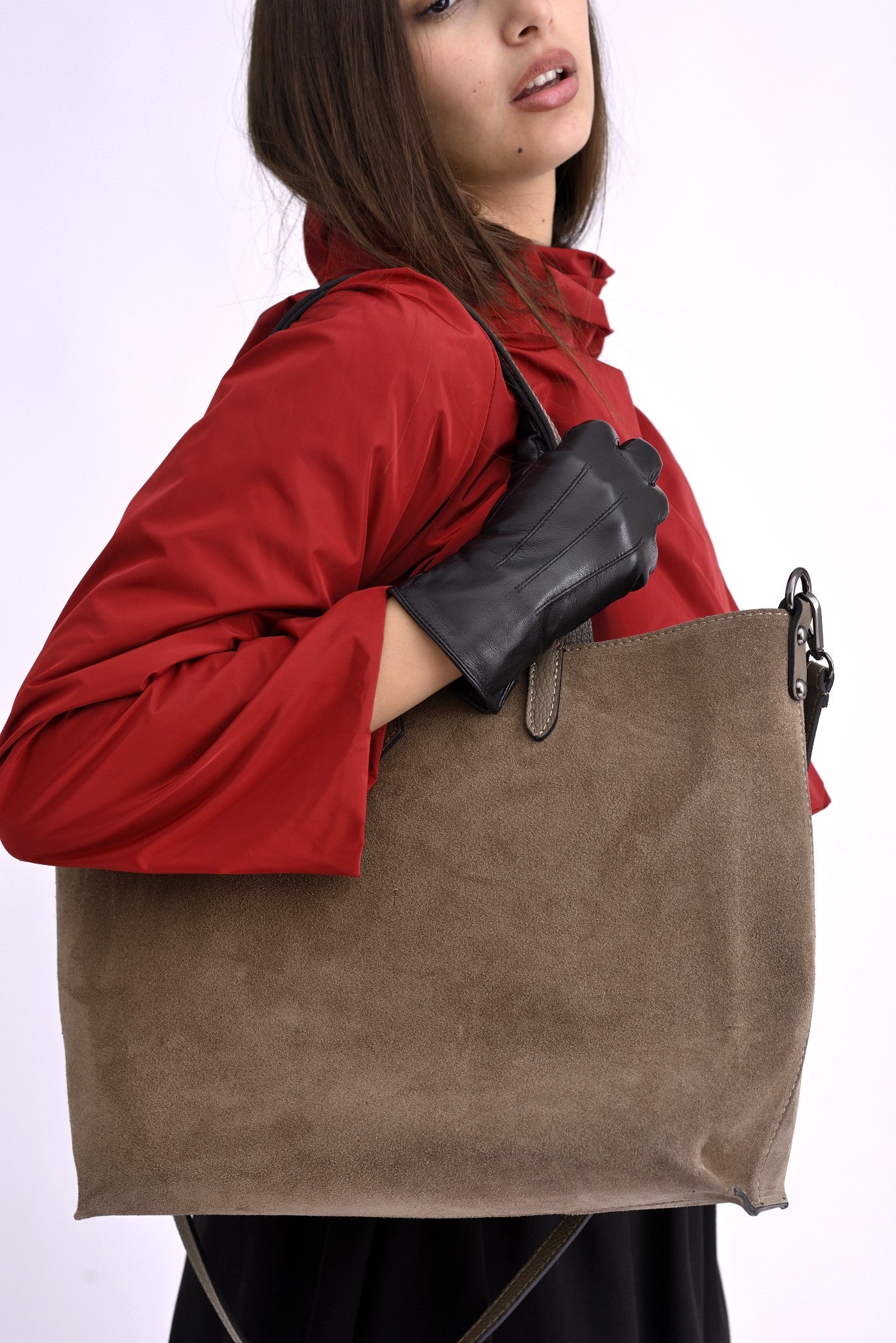 Model poartă geanta mare din piele întoarsă bej pe umăr, evidențiind dimensiunile și textura moale.