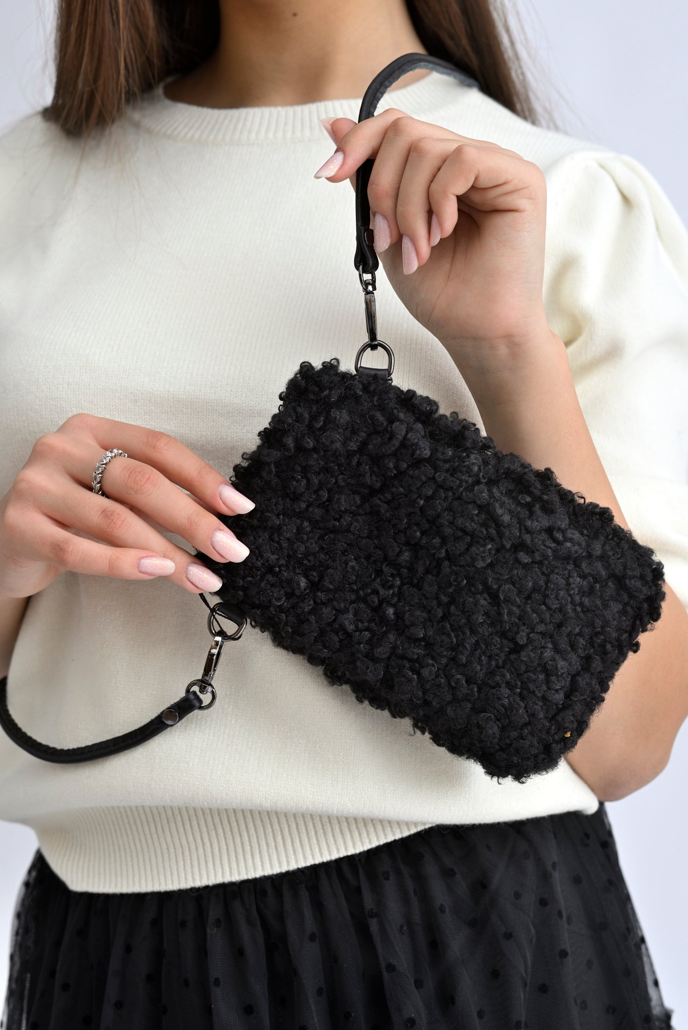 Geantă mică pentru telefon, din material textil bouclé negru, cu bretea subțire.
