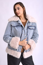 Gros-plan al manșetelor îmblănite ale jachetei din denim cu blăniță moale bej.