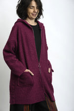 Jachetă midi bouclé în nuanță burgundy, cu glugă și buzunare aplicate, purtată peste ținută casual.