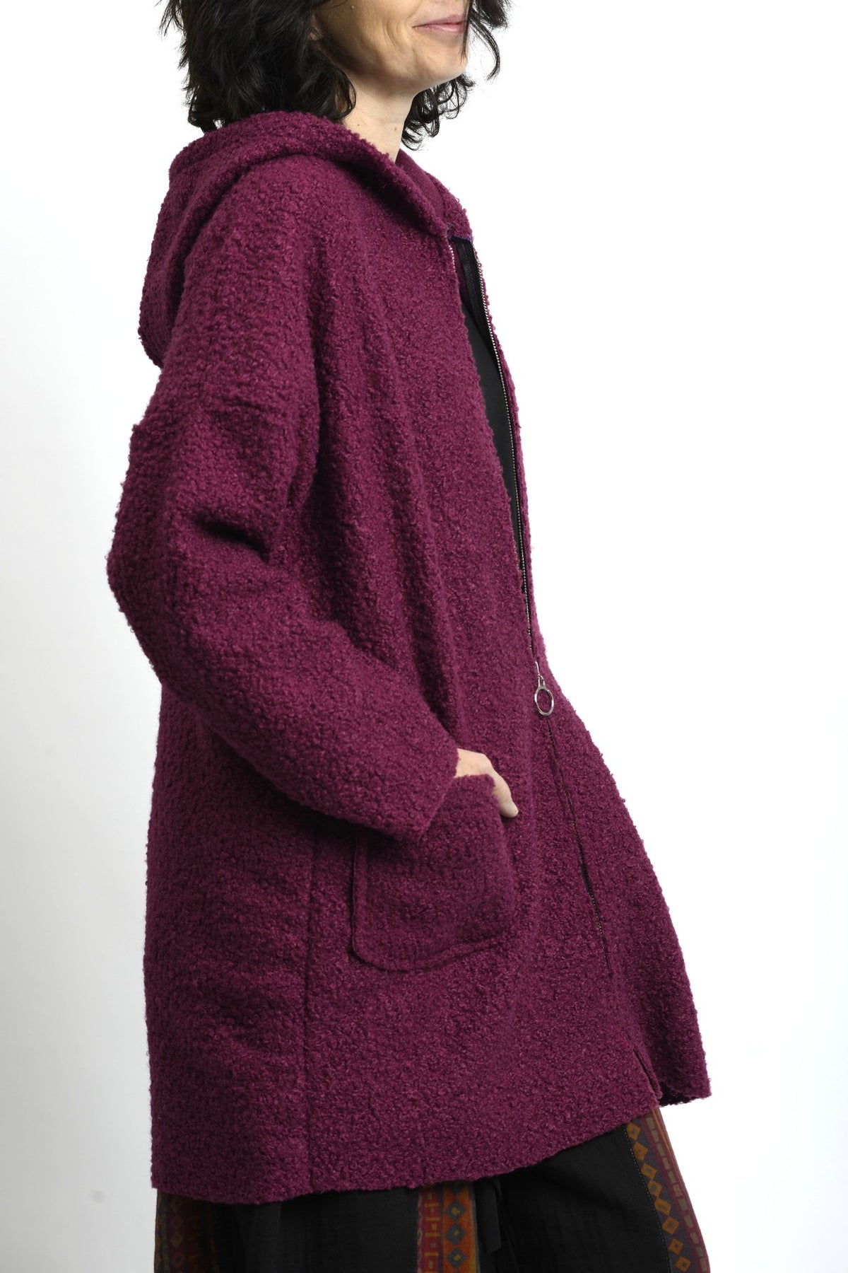 Spatele jachetei midi cu glugă, din material bouclé, cu cădere dreaptă.