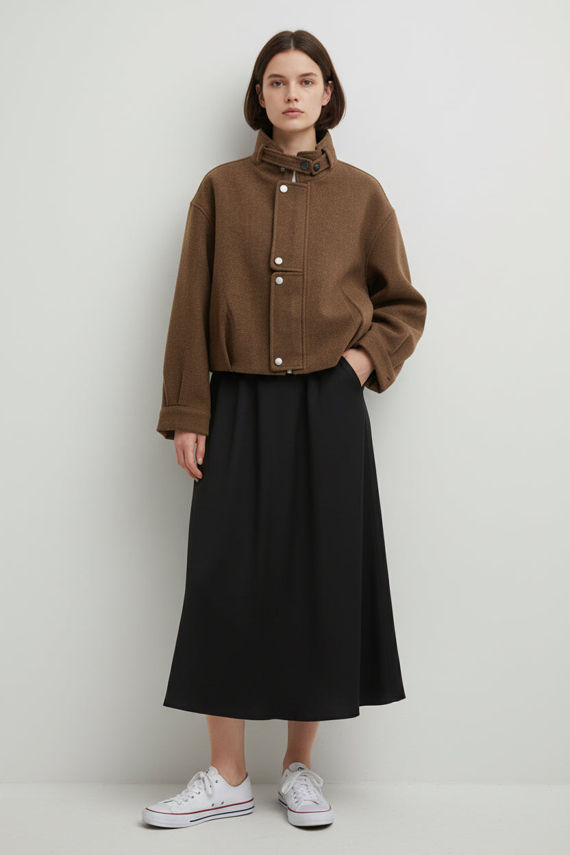 Jachetă scurtă maro, vedere frontală, croială lejeră și buzunare laterale discrete.