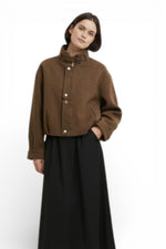 Jachetă maro cu guler înalt și închidere cu capse, textură mată, styling minimalist.