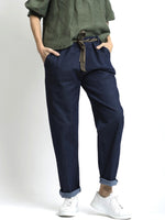 Pantaloni tip jeans elastici, croială conică, purtați cu pantofi sport albi, vedere frontală.