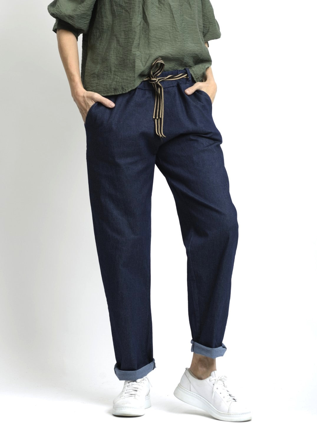 Pantaloni tip jeans elastici, croială conică, purtați cu pantofi sport albi, vedere frontală.