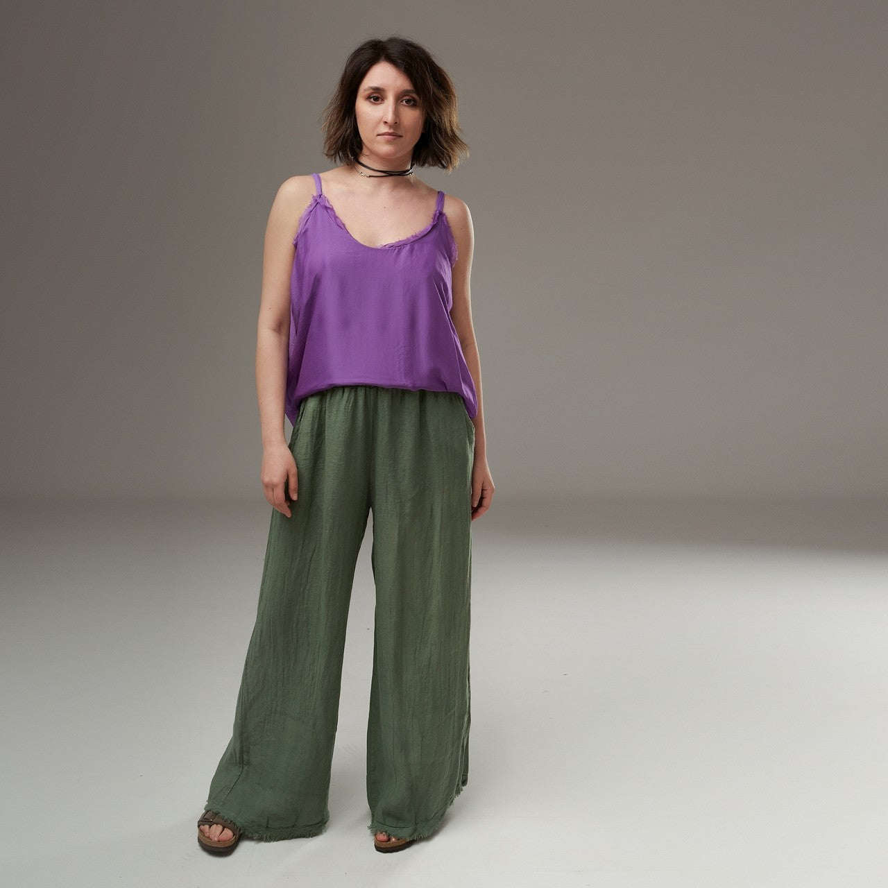 Ținută completă cu maieu mov din mătase și pantaloni verzi largi, pentru un look boem de vară.