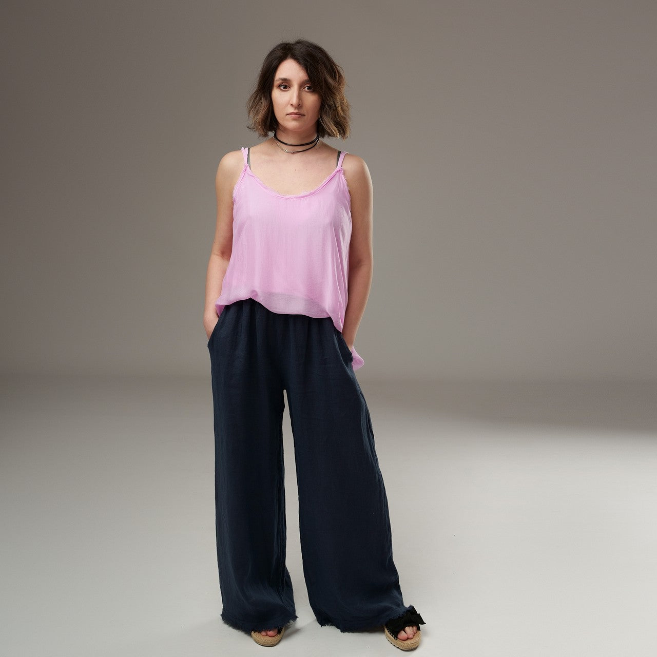 Maieu roz pal cu bretele, purtat cu pantaloni evazați bleumarin – look lejer și feminin.