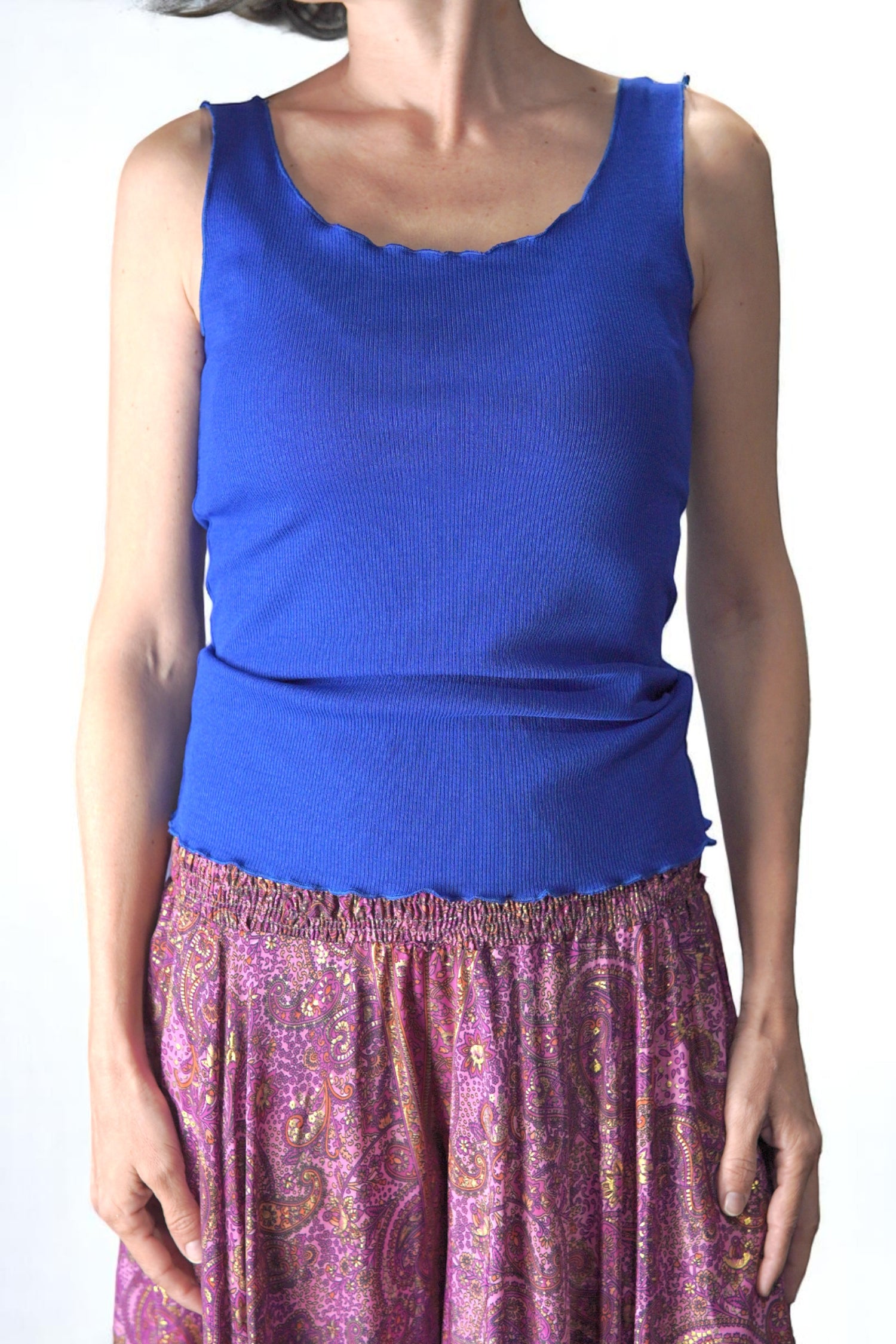 Maiou bleumarin cu decolteu rotund și tiv ondulat, confecționat din material elastic, purtat cu fustă-pantalon fucsia. Ideal pentru layering sau purtat ca atare în sezonul cald.